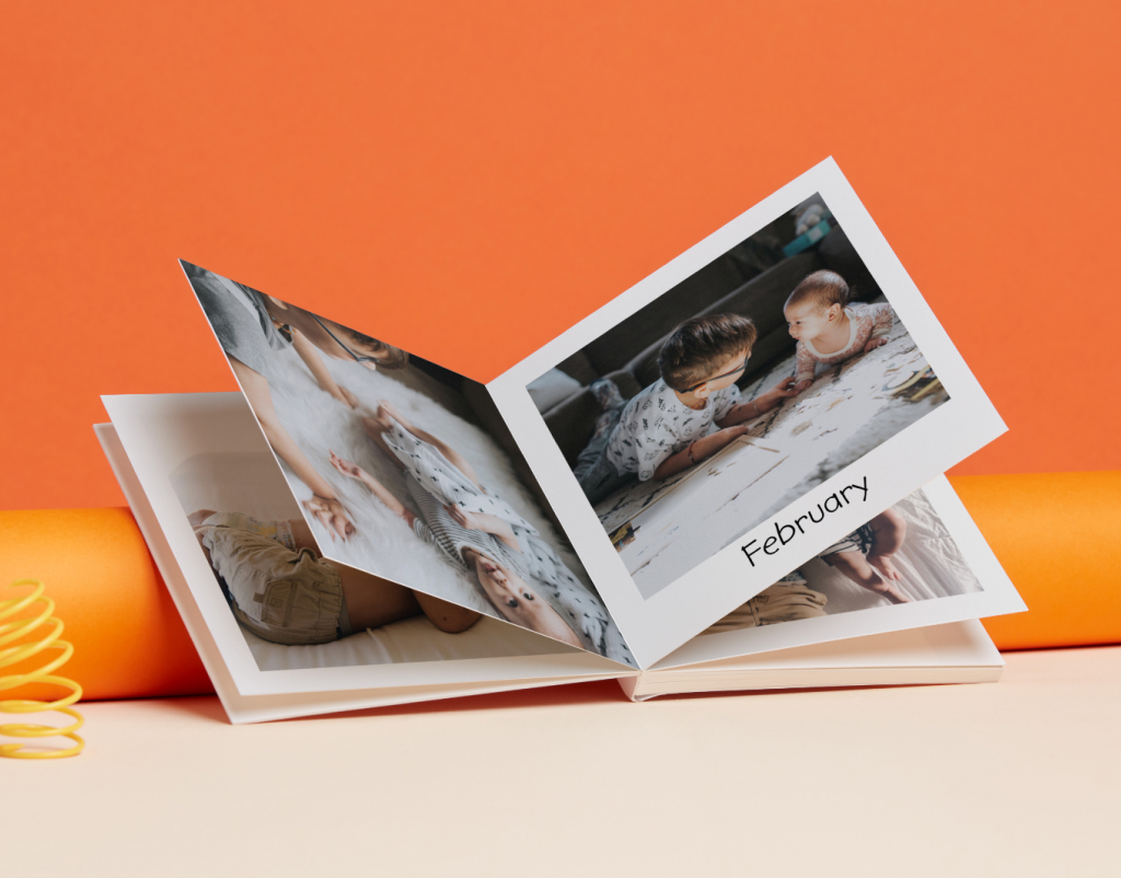 A Little Moments Photo Book, open to pages featuring photos of babies with a caption that reads 