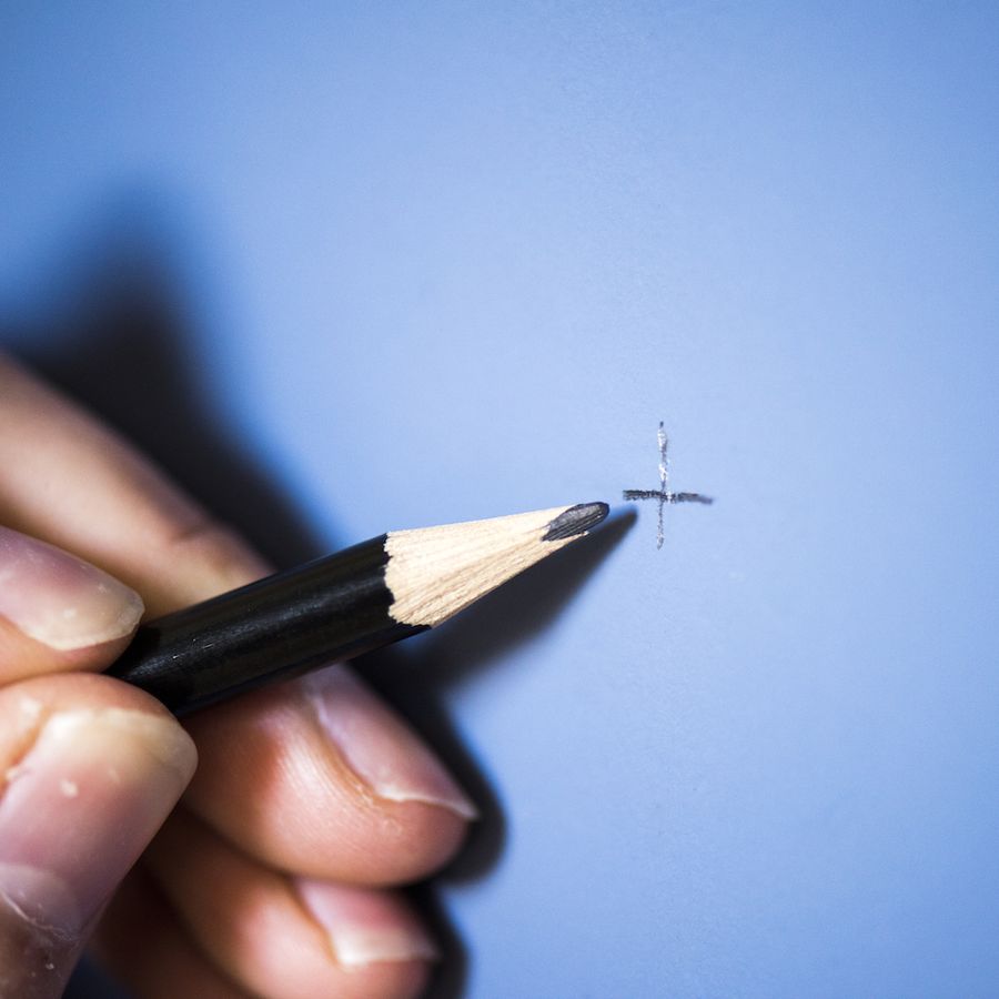 pencil marking a blue wall to hang a canvas