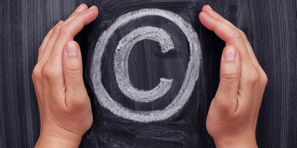 Hands protecting copyright symbol