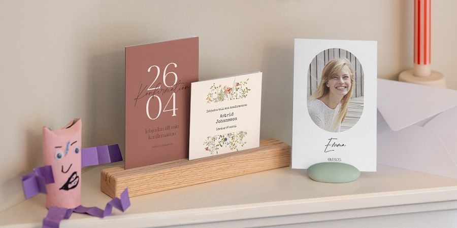 A range of different first holy communion invitations from Photobox displayed together on a shelf.