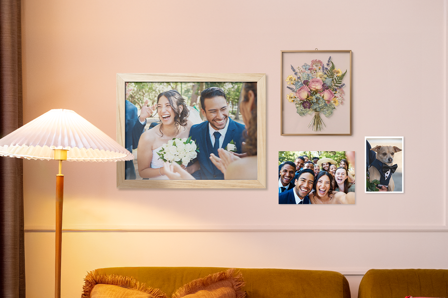 Wedding wall decor ideas from Photobox shown in a living room gallery wall with pictures of a bouquet, a wedding party, the newlyweds, and a dog wearing a tuxedo.
