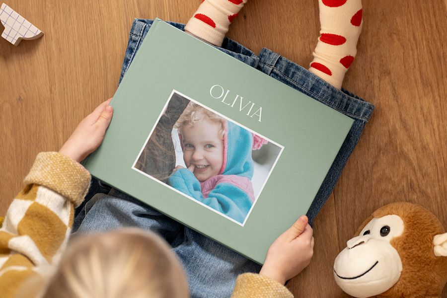 Personalised baby photo album featuring a happy baby girl, ideal for discovering what to write in a photo album with cute baby captions and quotes.