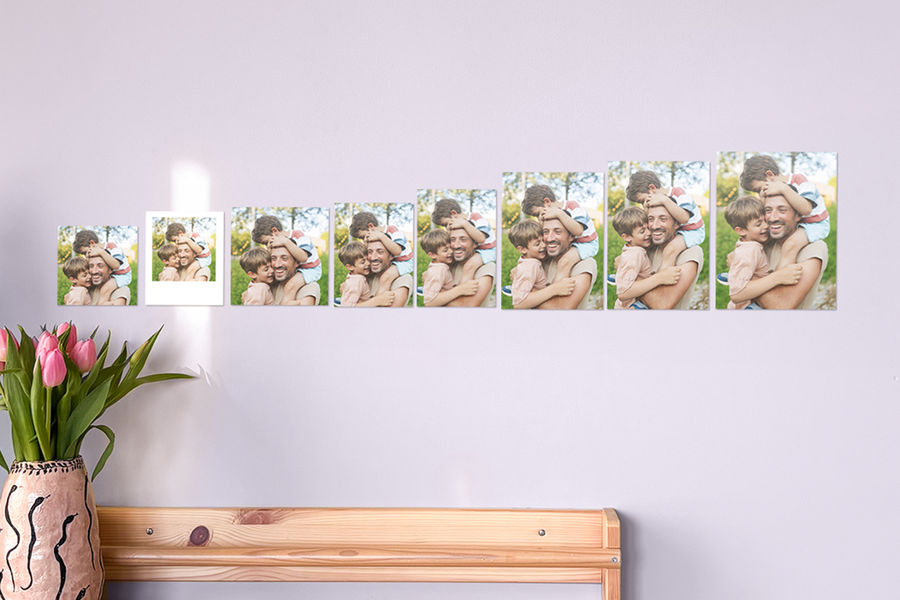 Photobox photo prints of the same father and sons embracing displayed in different sizes on a wall, showing standard photo prints, square photo prints and larger photo prints to help you choose the right photo print size when ordering photo prints online.