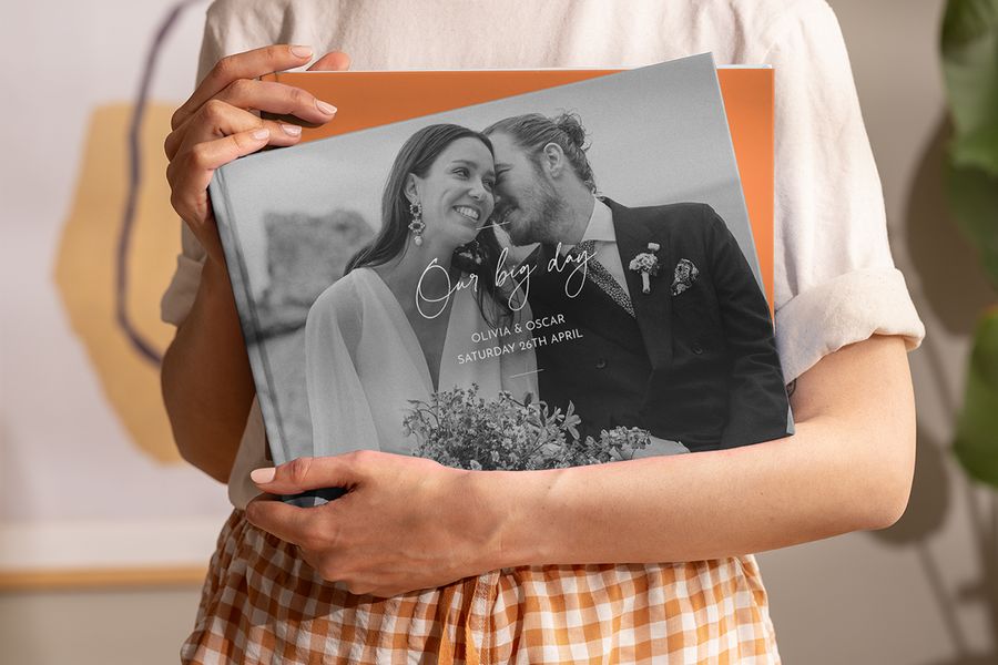 A woman holding a personalised Photobox wedding coffee table photo book in her hands, inspiring a wedding coffee table book and a custom coffee table photo book.