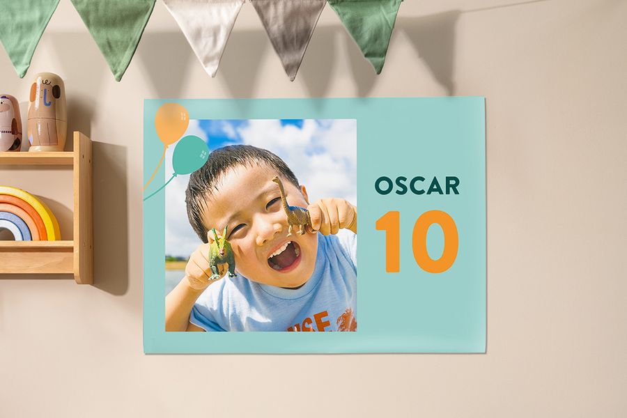 A personalised Photobox poster used as a decoration at a child’s party, showing a little boy holding dinosaurs to celebrate his 10th birthday, inspiring children’s party decorations and children’s birthday party ideas.