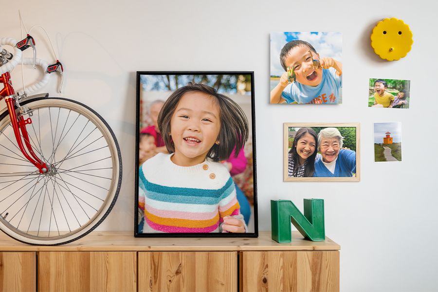 Various family photos are displayed in different layouts on a wall alongside home decor and wall hangings, inspiring photo wall decoration ideas and a spring home refresh with photo prints for walls.