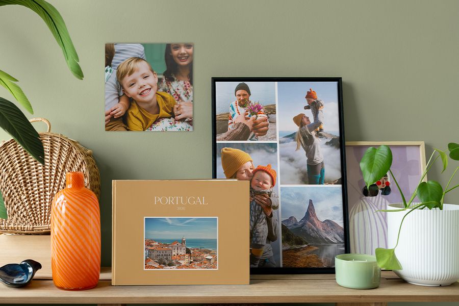 A personalised travel photo book sits beside a framed photo collage and a family photo print on the wall, inspiring ways to make your space feel like home with meaningful photo decor.