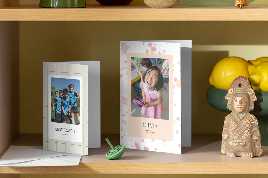 Two different personalised Photobox thank you teacher cards displayed on a shelf in a home.