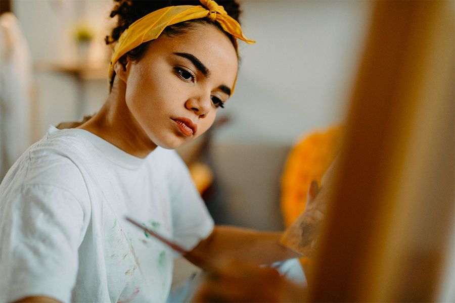 A woman paints, capturing the spirit of Photobox's solo staycation ideas.