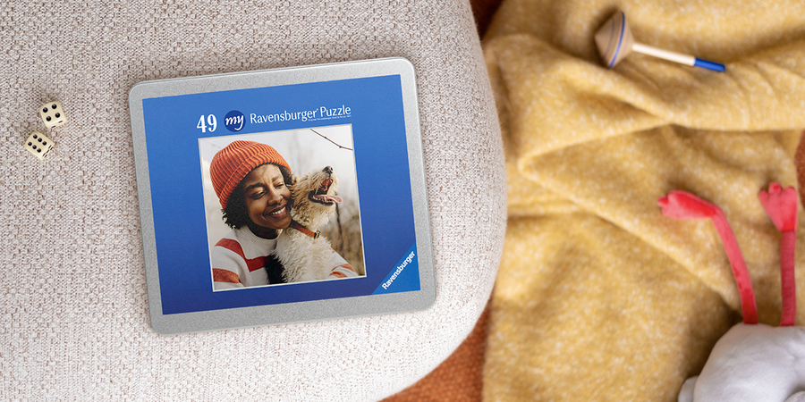 A personalised Photobox jigsaw puzzle featuring a woman and her dog sits beside dice and a wooden spinner toy, inspiring kids travel games and children’s travel activity ideas.