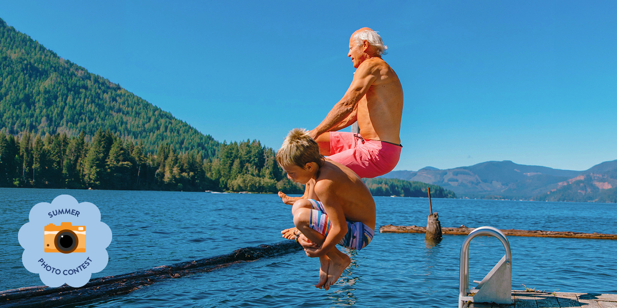 Old man and young boy jumping into the sea, capturing a joyful summer moment for the Photobox Summer Photo Contest.
