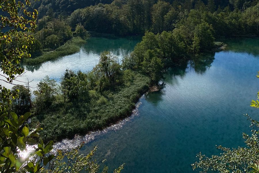 Cascading emerald waterfalls and wooden boardwalks over turquoise water at Plitvice Lakes National Park in Croatia, one of the most beautiful national parks in Europe featured in Photobox's guide.