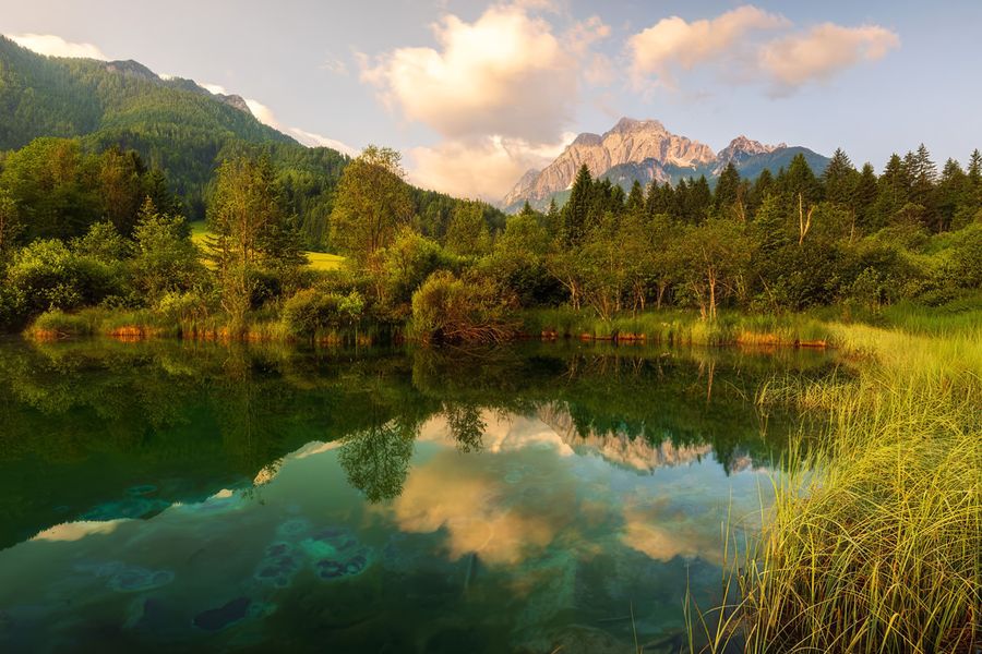 Towering limestone peaks and the clear reflective waters of Lake Bohinj at Triglav National Park in Slovenia, one of the best national parks in Europe featured in Photobox's guide.