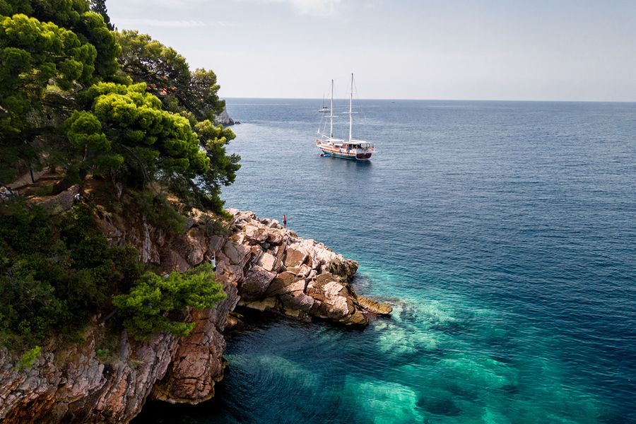 Bright turquoise sea nestled between chalky white limestone cliffs at Calanques National Park in France, one of the best national parks in France featured in Photobox's guide.