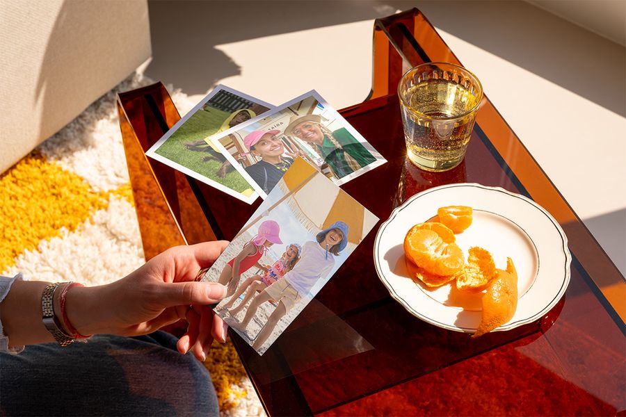 Someone looks at a selection of lovely photo prints, illustrating how Photobox can help turn organised photos into something to treasure.