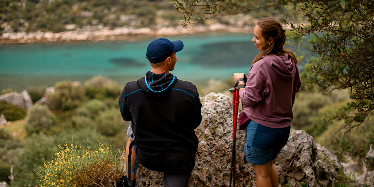 A couple stands in a beautiful national park looking out at a blue lake, capturing the natural beauty featured in Photobox's guide to the most beautiful national parks in Europe.