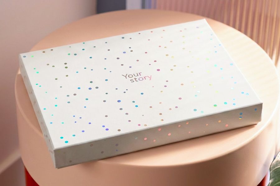 The closed presentation box rests on a stool, showcasing the finished look of Photobox's new photo book gift box.
