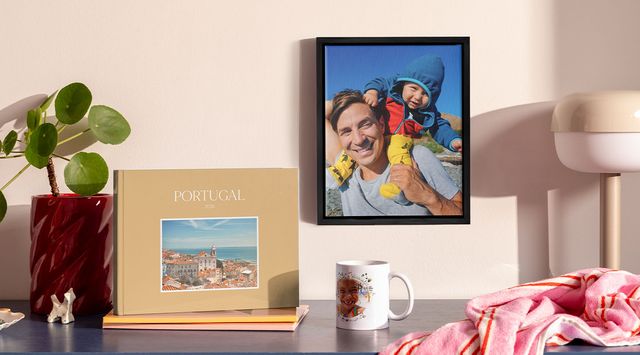 Collection of personalised photo products displayed on a shelf, including a photo book, framed print and mug.