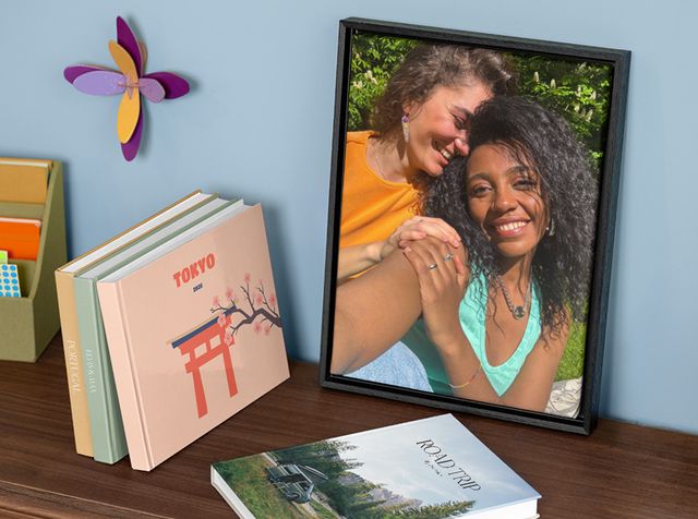 A personalised wall art piece and several personalised photo books on a shelf