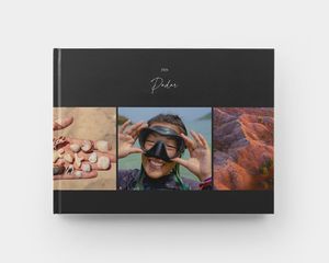 A closed landscape hardcover photo book with summer images on the cover