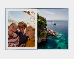 A large portrait photo book with an image of a person looking at a mountain lake