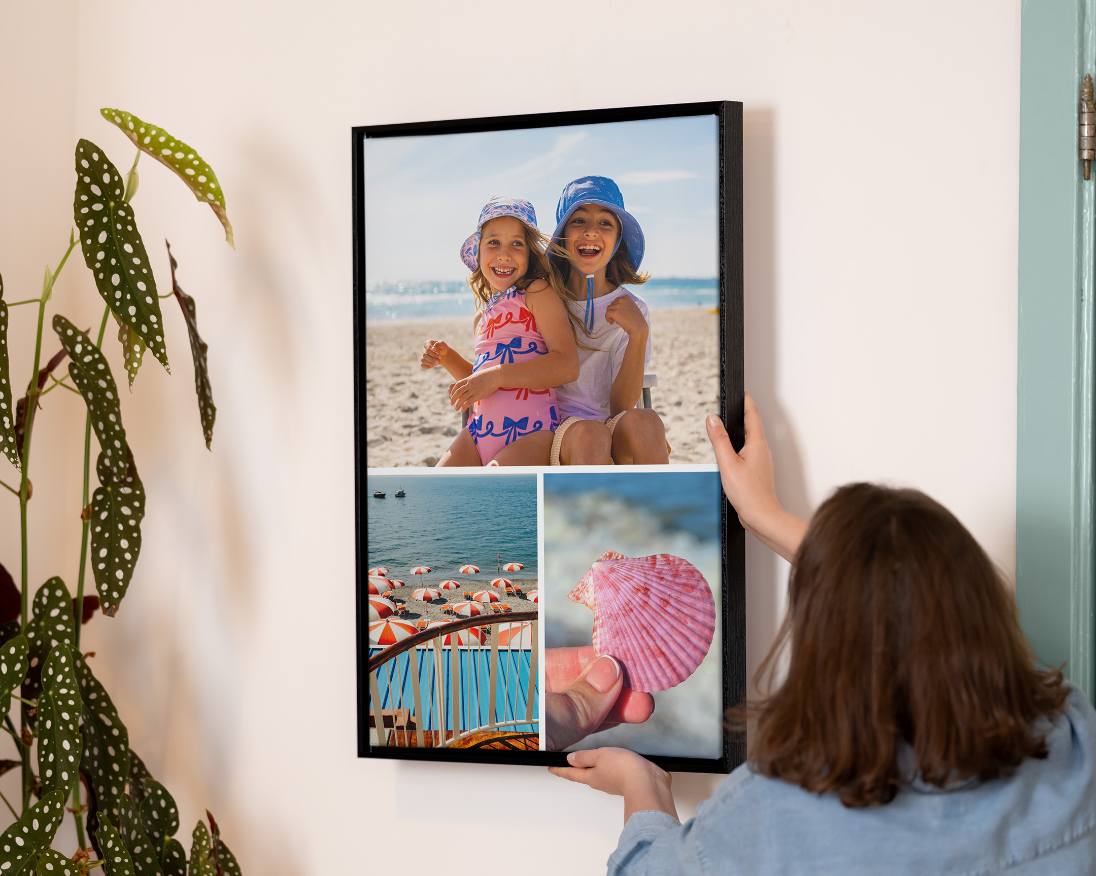 Person hanging a framed collage print