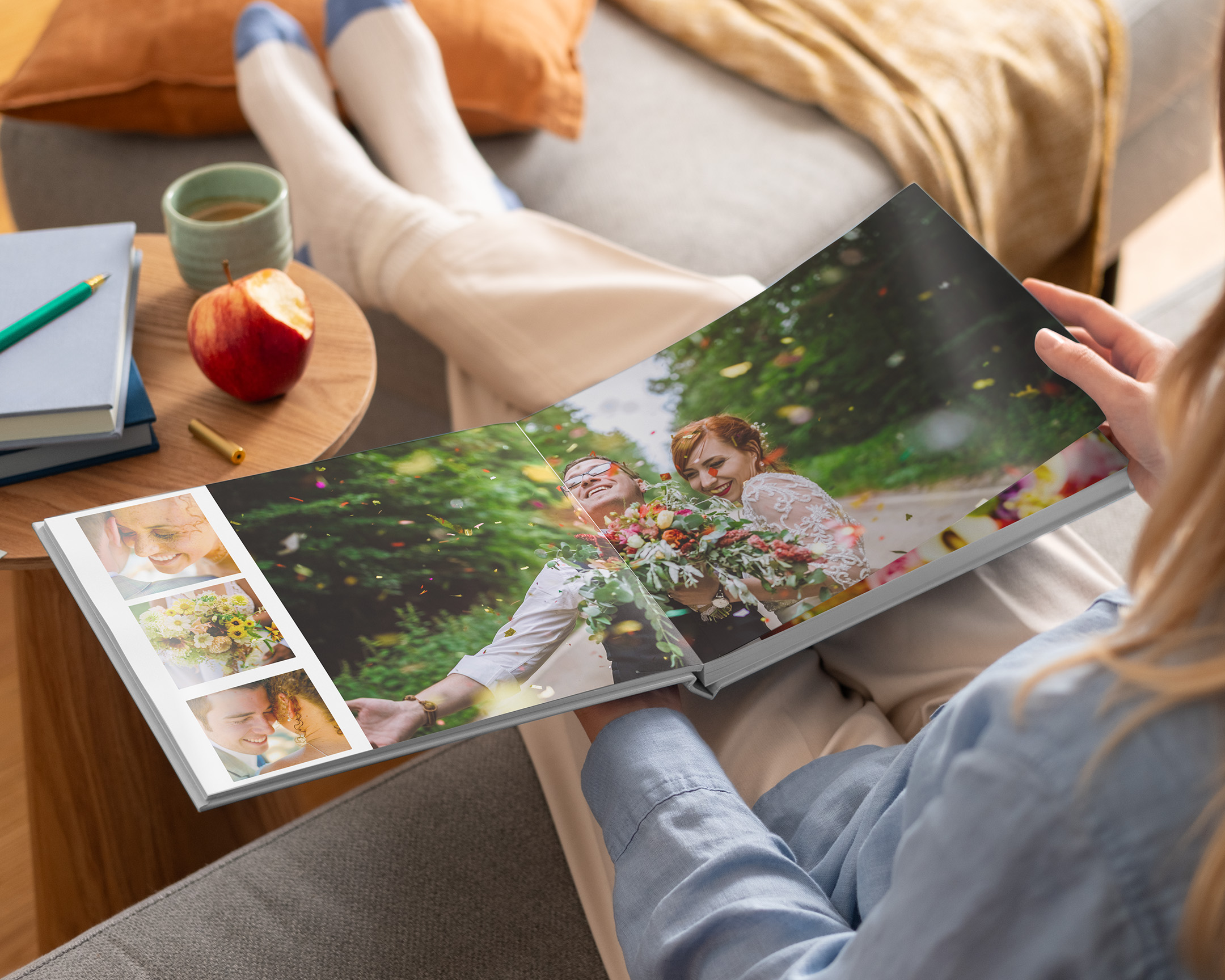 Woman looking at an open layflat photo book with wedding photos.