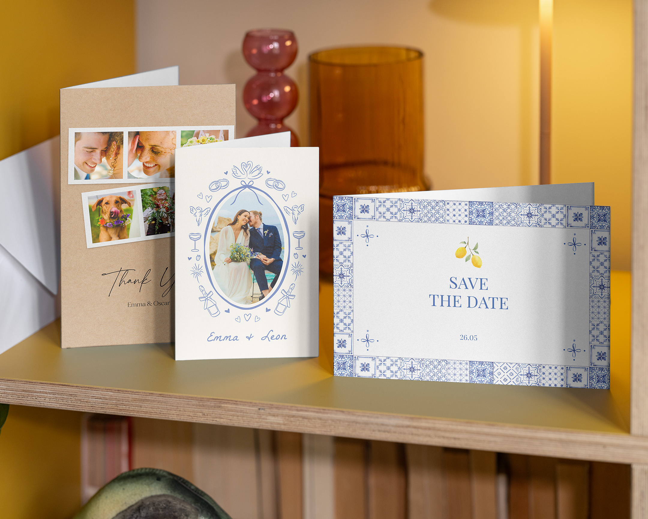 Three wedding photo cards on a shelf: one save-the-date and two thank-you cards.