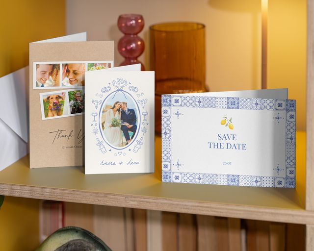 Three wedding photo cards on a shelf: one save-the-date and two thank-you cards.