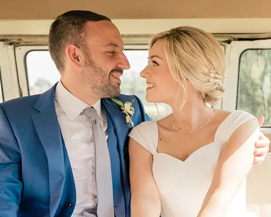 Photobox editorial content specialist Fee and her husband smiling in their wedding car, illustrating a personal story about wedding planning tips