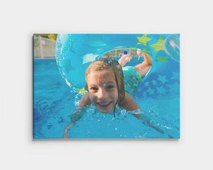 Canvas print of a child swimming underwater in a pool.