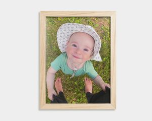 Wooden framed poster of a baby and an orange print.